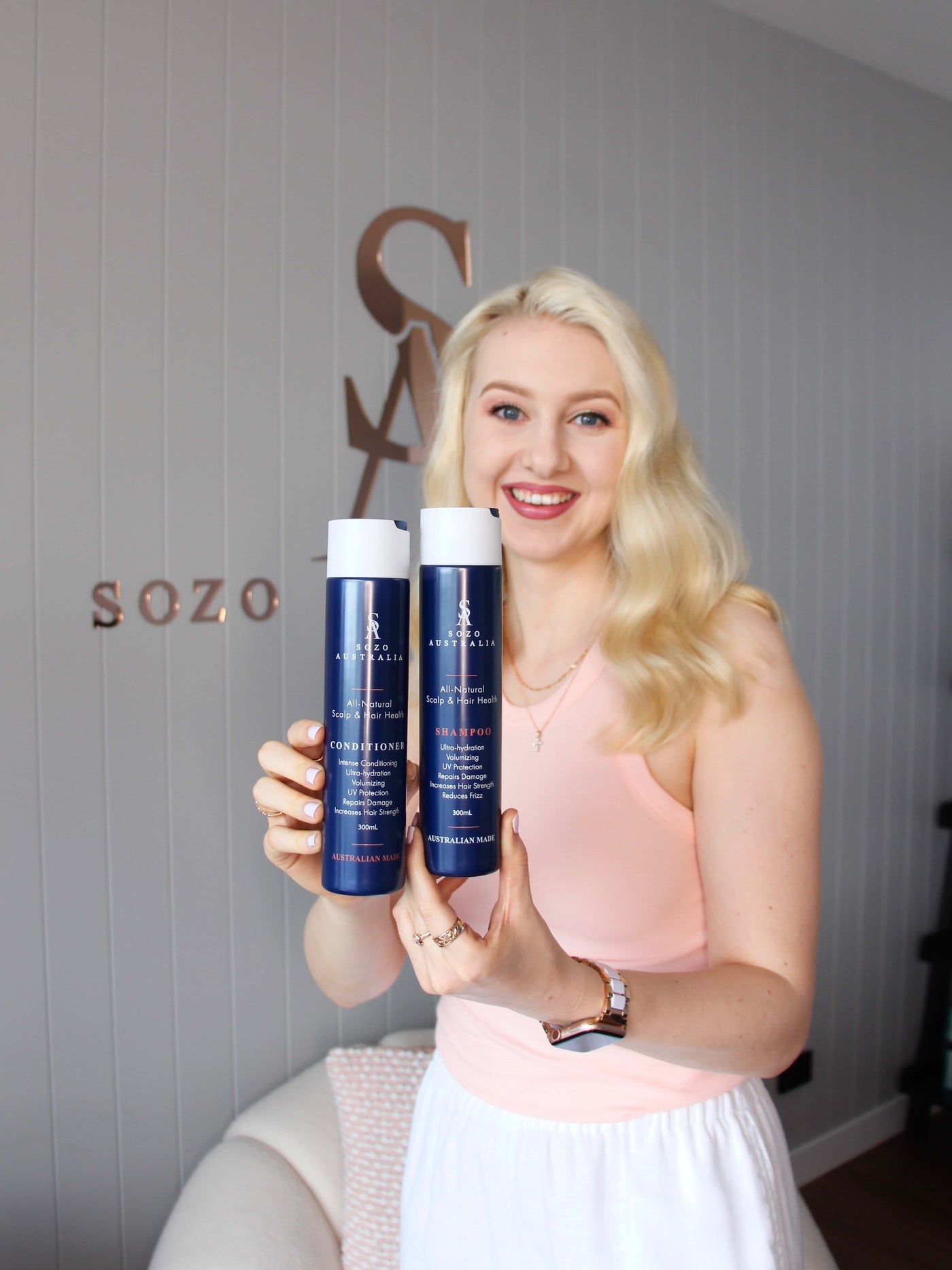 Sozo Australia founder holding Sozo Hair Health Shampoo and Conditioner bottles