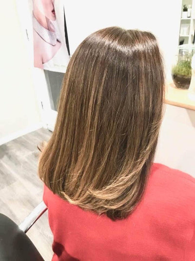 Woman with short brown hair sitting in Australian hair salon after using Sozo Hair Health products